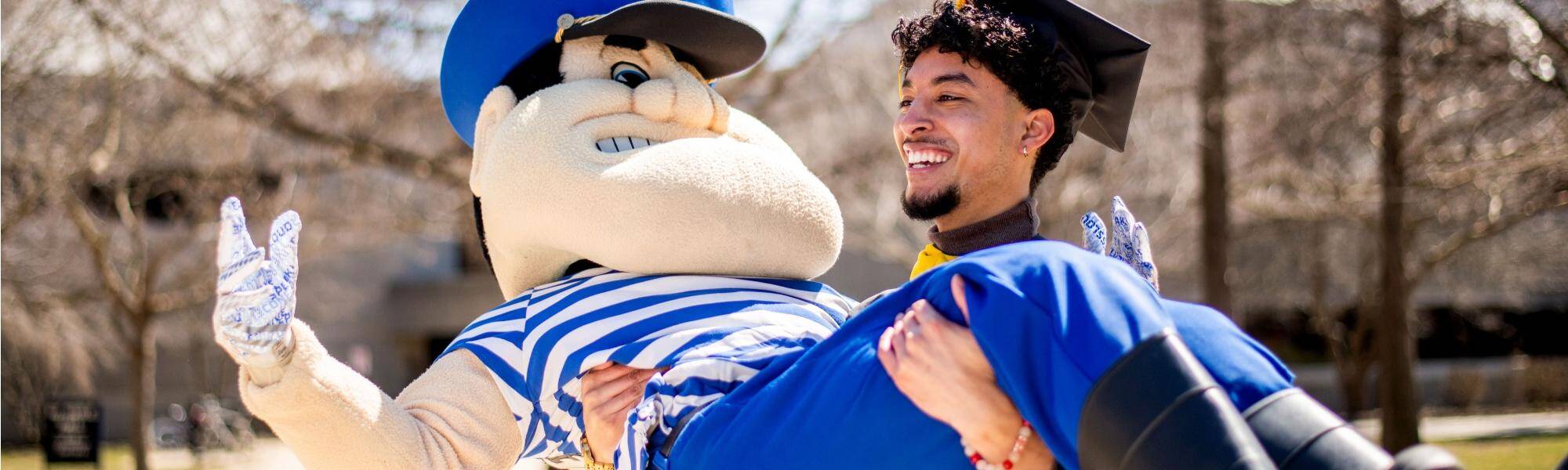 Graduating student carrying Louie the Laker